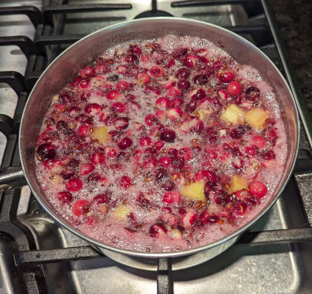 serviceberries and rhubarb boiling in a saucepan