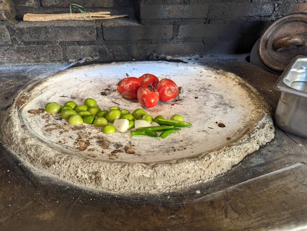tomatoes, tomatillos, and green chilis roasting on a comal in Oaxaca