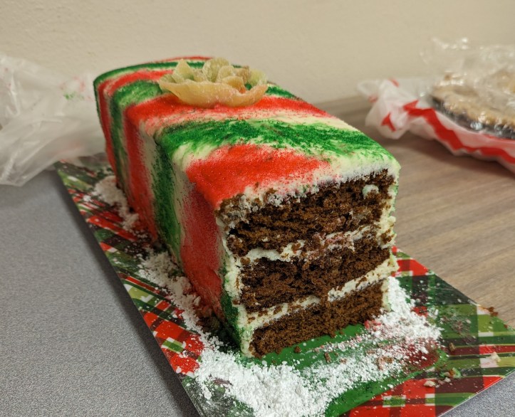 Gingerbread cake with ginger buttercream frosting and a candied ginger rose on a holiday platter