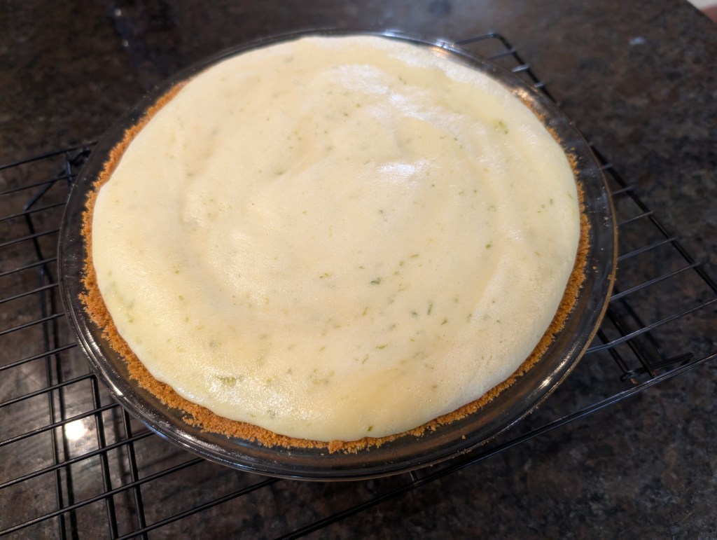 Key lime pie with a graham cracker crust, cooling after baking