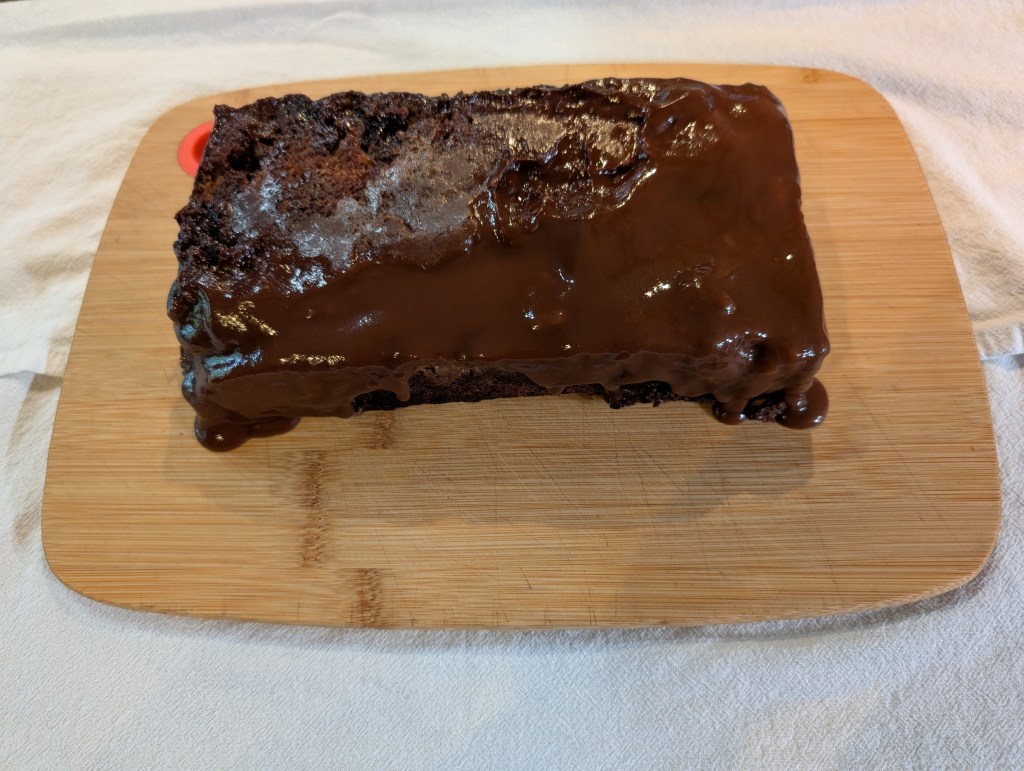 The pudding dumped upside down on a cutting board. There is a lot of liquid showing that didn't bake properly.