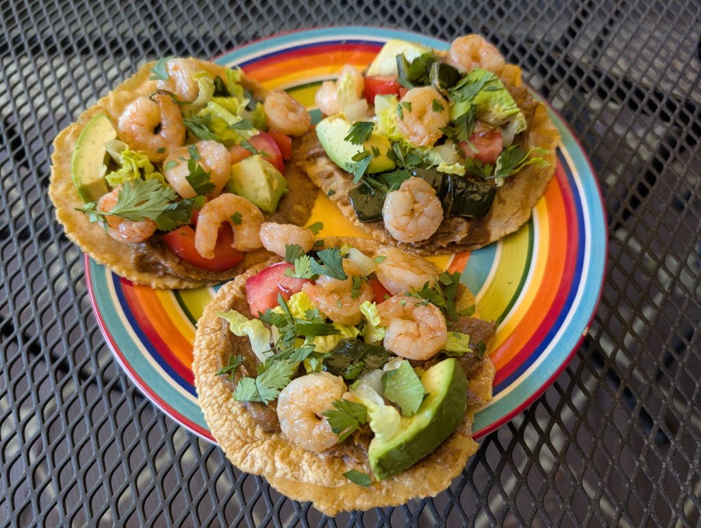 Mole amarillo smeared on homemade tortillas with shrimp, lettuce, tomato, avocado, poblano, and cilantro
