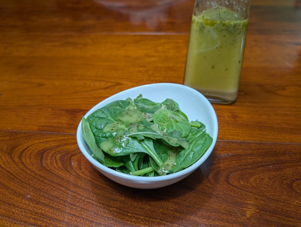 Secret salad dressing in a bottle and drizzled onto a bowl of greens