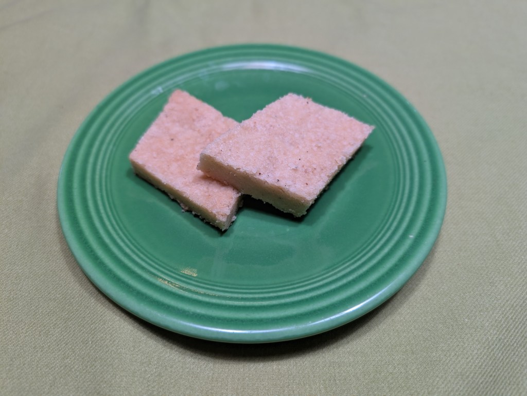 two pieces of cardamom shortbread cut into diamond shapes
