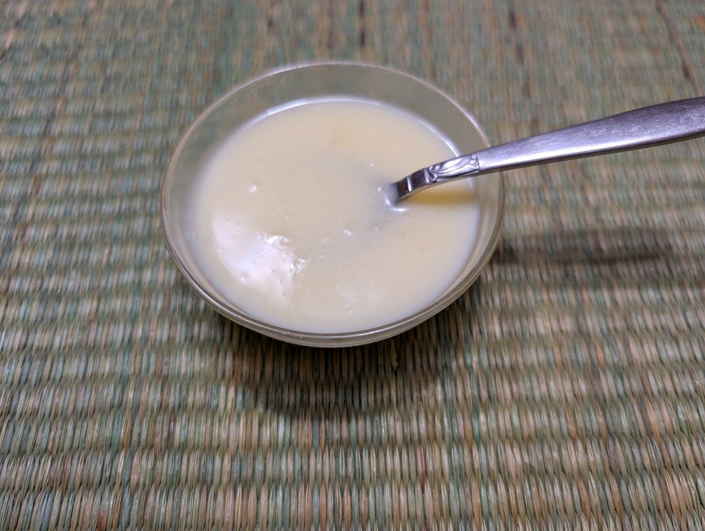 Sweet cream sauce in a tiny serving bowl with a spoon