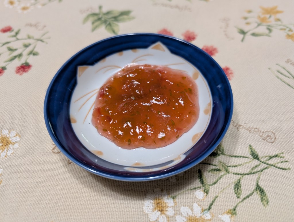 a spoonful of gooseberry rhubarb jam on a tiny saucer