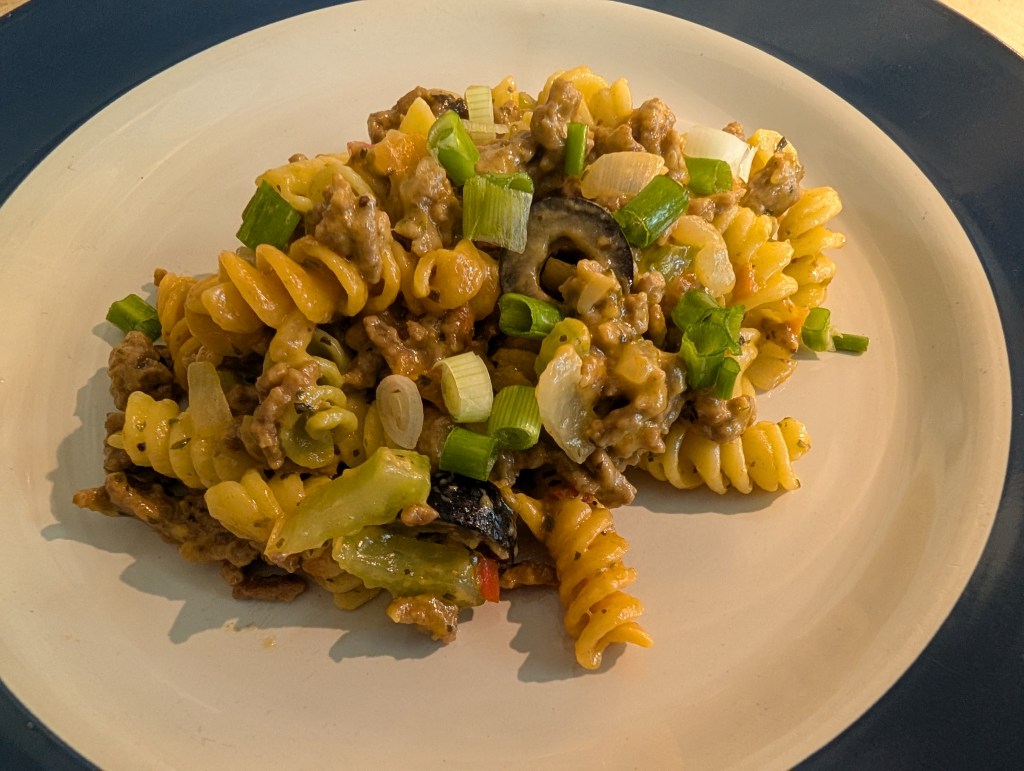 Hamburger Heaven with rotini noodles served on a plate and garnished with green onions