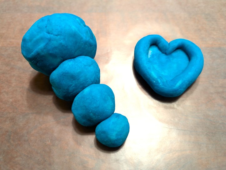 Blue play dough on wax paper