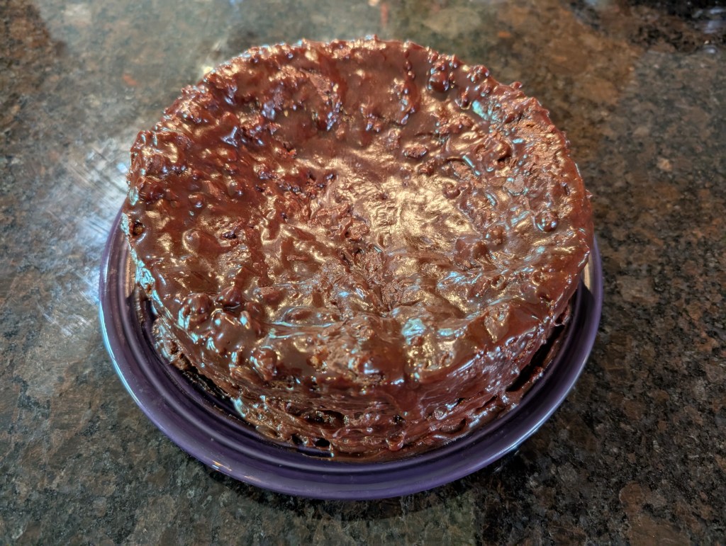 Chocolate icing drizzled onto a Heath Bar Cake