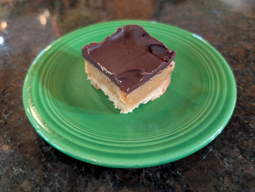 a small square of millionaire shortbread on a saucer