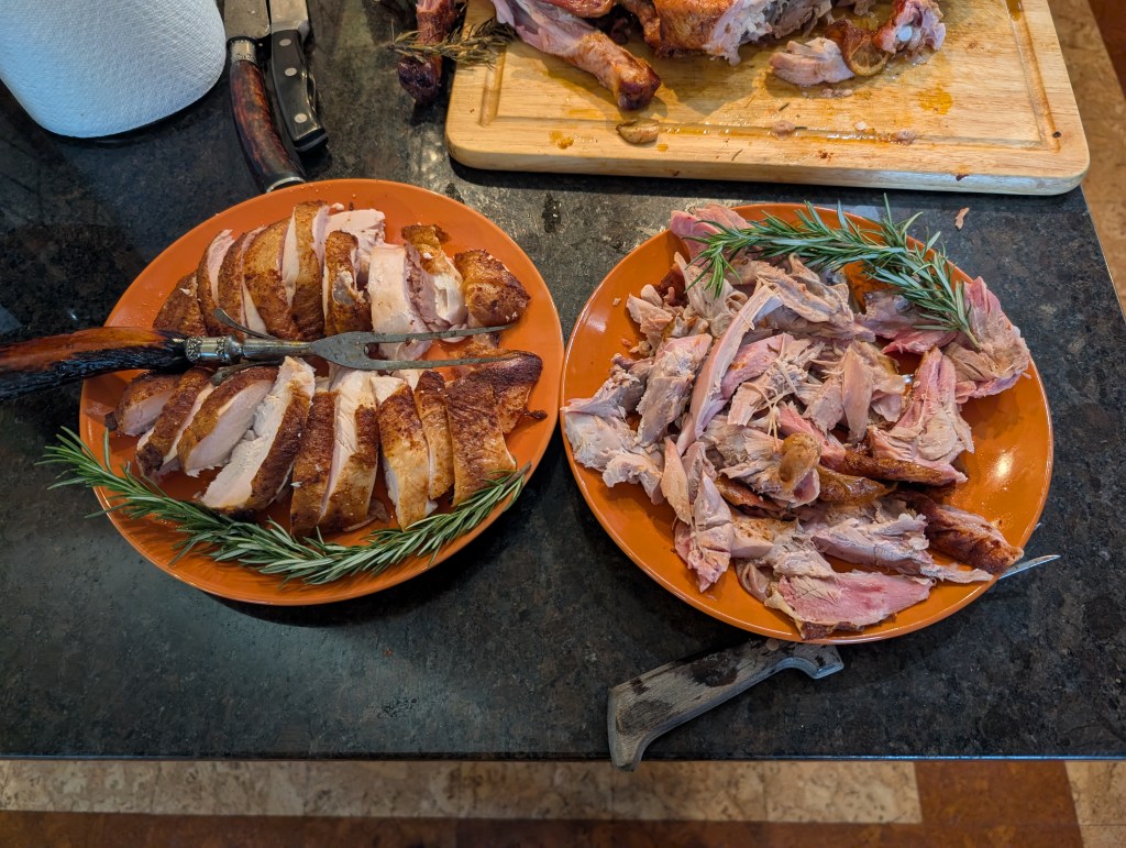 smoked turkey, carved and separated into two plates by white meat and dark meat