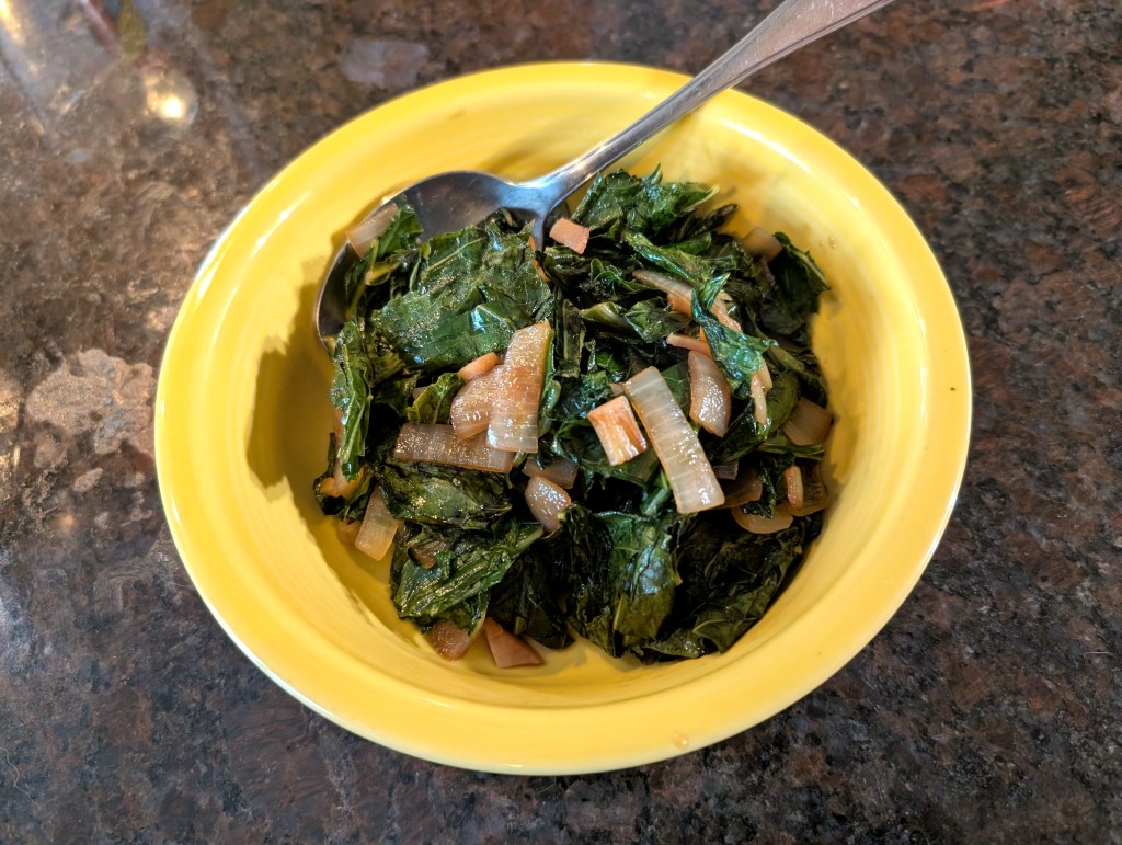 Collard Greens with onions and garlic served in a shallow bowl